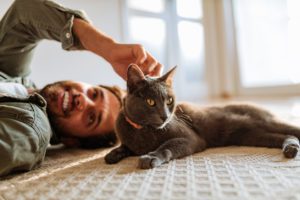 Man And Cat At Home Playing On The Floor And Cuddling During Lockdown